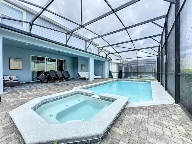 view of pool featuring glass enclosure, an in ground hot tub, and a patio