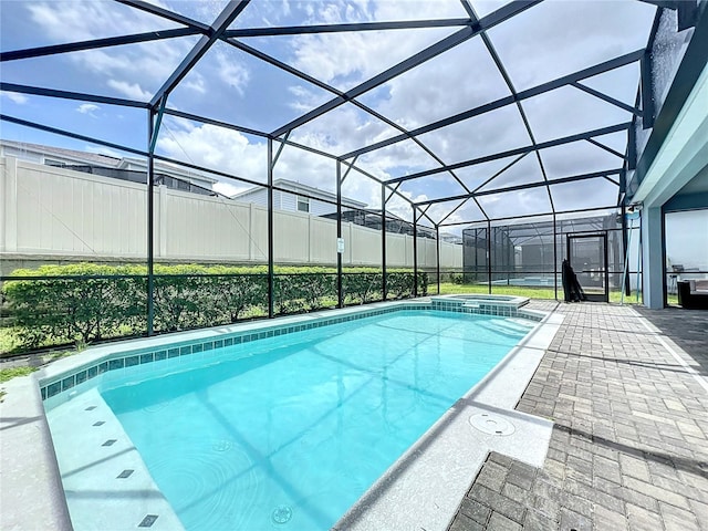 view of swimming pool featuring a patio area and a lanai