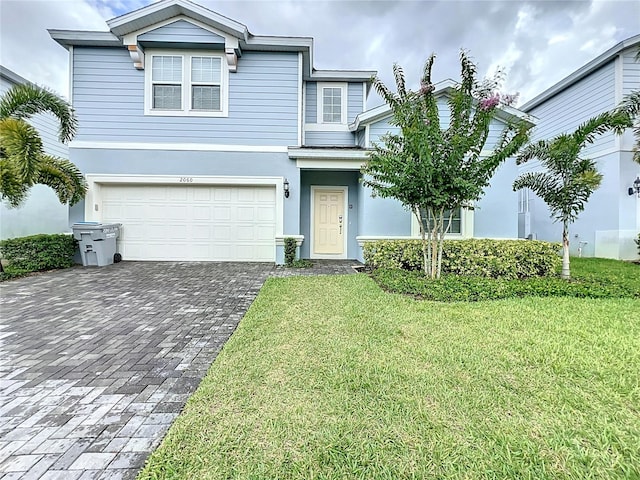 view of front of home with a front yard and a garage