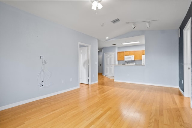 unfurnished living room with rail lighting, light hardwood / wood-style flooring, and vaulted ceiling