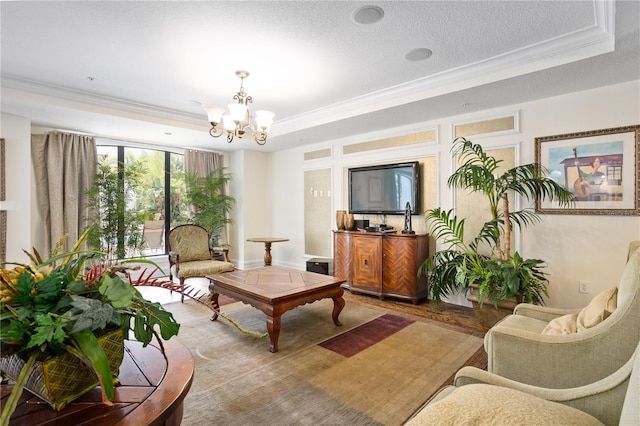 living room featuring a raised ceiling, crown molding, and a chandelier