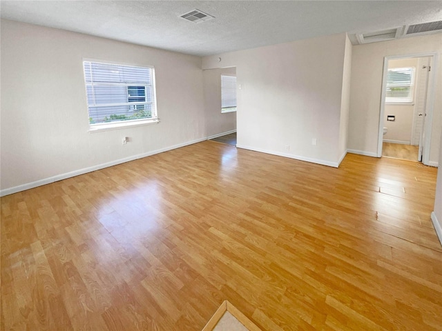 empty room featuring light hardwood / wood-style floors and a textured ceiling