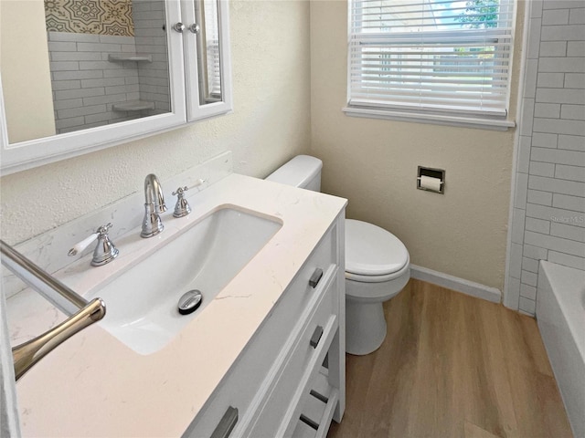 full bathroom featuring tiled shower / bath, hardwood / wood-style floors, vanity, and toilet