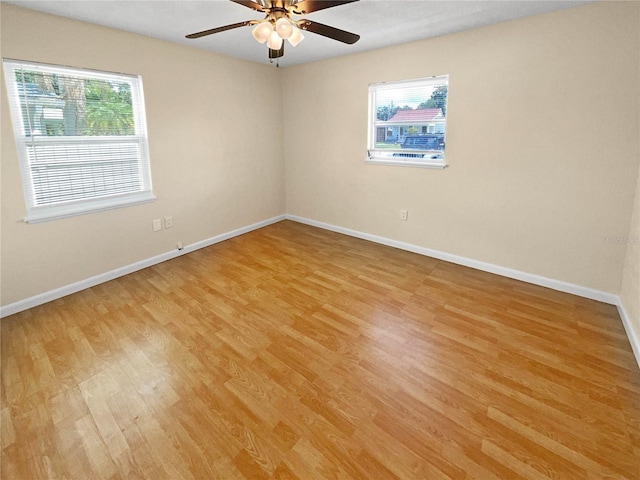 empty room featuring plenty of natural light, light hardwood / wood-style floors, and ceiling fan