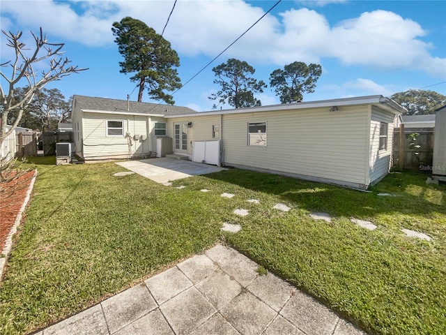 rear view of house with french doors, fence, a patio, and a lawn