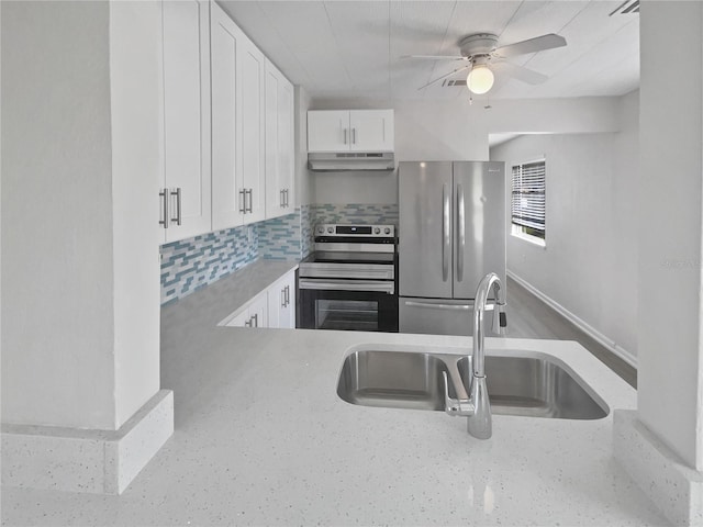 kitchen with light stone counters, under cabinet range hood, stainless steel appliances, a sink, and white cabinets