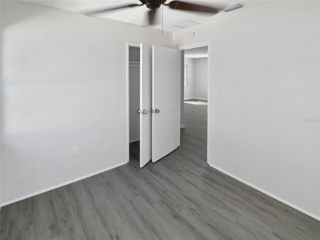 unfurnished bedroom with baseboards, visible vents, ceiling fan, and wood finished floors