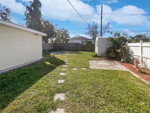 view of yard with a patio area, an outdoor structure, and a fenced backyard