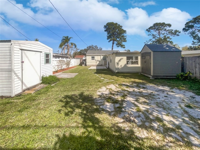 view of yard with a fenced backyard, an outdoor structure, and a shed