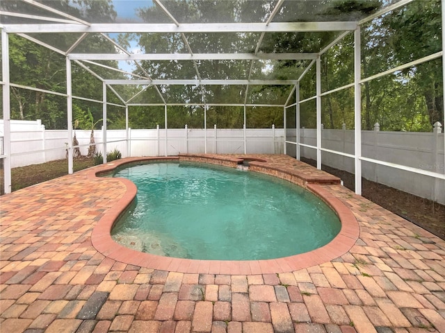 view of pool with a patio and glass enclosure