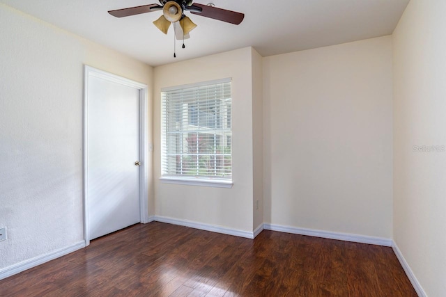 spare room featuring dark wood-type flooring and ceiling fan