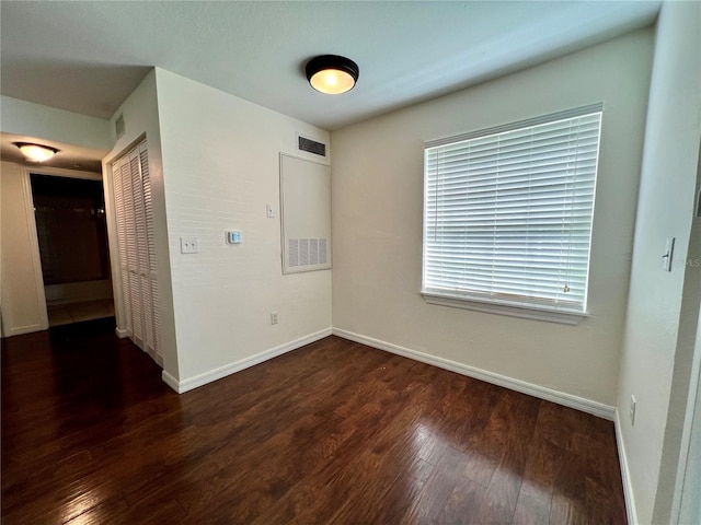 unfurnished room with dark hardwood / wood-style flooring