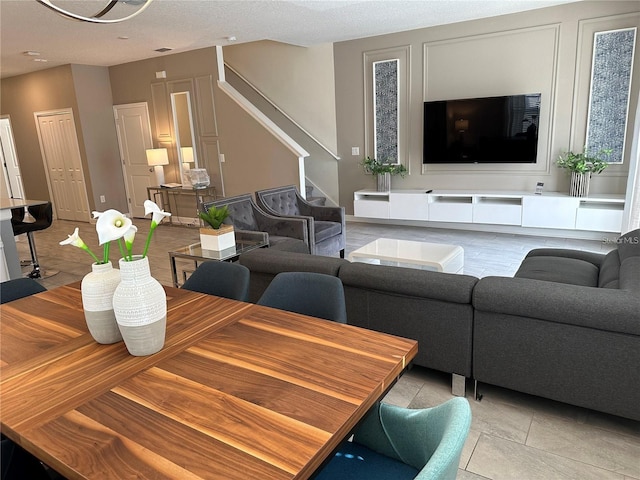 living area with stairway and light tile patterned floors