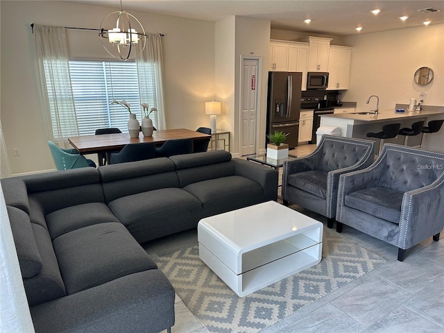 living room featuring an inviting chandelier, baseboards, visible vents, and recessed lighting