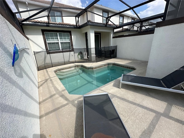 pool featuring glass enclosure and a patio