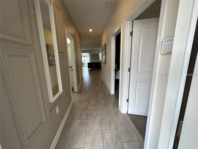 hallway with recessed lighting and baseboards