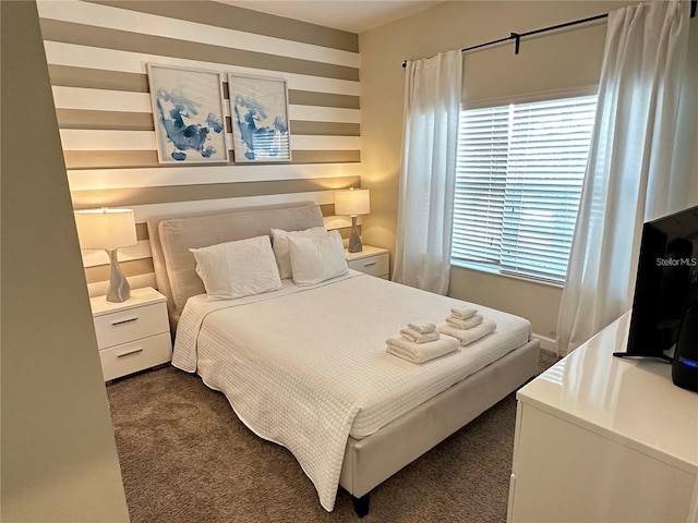 bedroom with dark carpet and wood walls