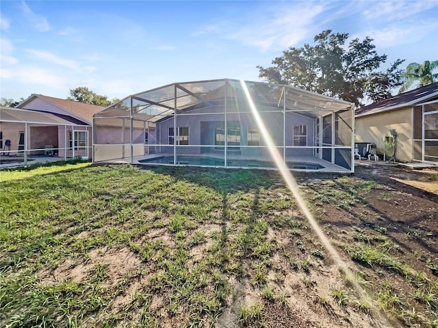 back of house featuring glass enclosure and a lawn