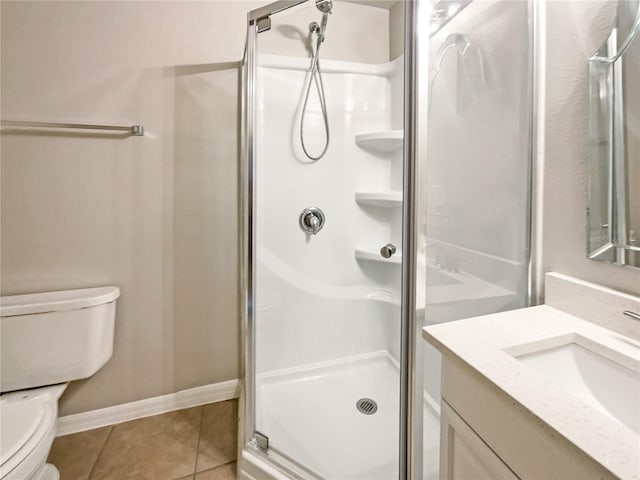 bathroom featuring tile patterned floors, vanity, toilet, and a shower with shower door