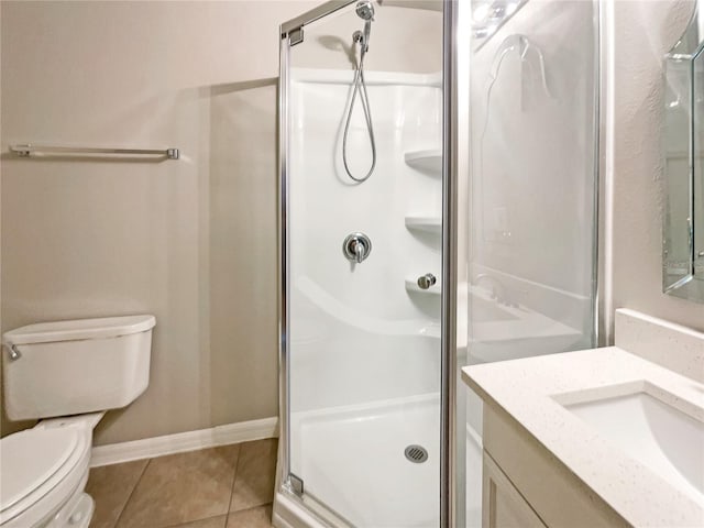 bathroom featuring tile patterned floors, vanity, toilet, and a shower with shower door