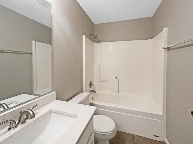 full bathroom featuring tile patterned floors, vanity, a textured ceiling, washtub / shower combination, and toilet