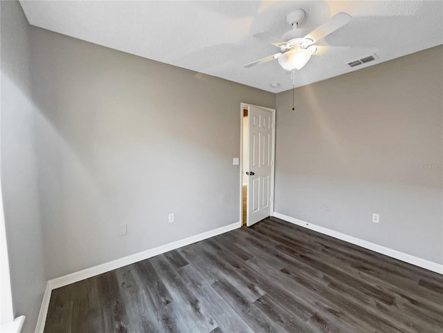 spare room with ceiling fan and dark hardwood / wood-style flooring