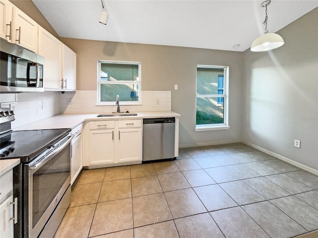 kitchen with sink, decorative light fixtures, decorative backsplash, white cabinets, and appliances with stainless steel finishes