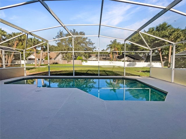 view of pool with glass enclosure and a yard