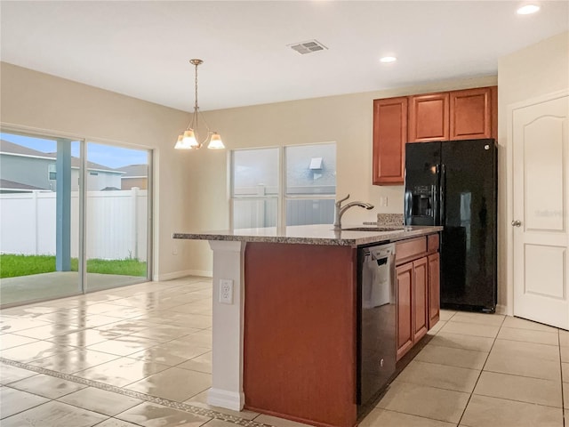 kitchen featuring a chandelier, pendant lighting, an island with sink, and black appliances