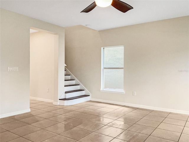 tiled empty room featuring ceiling fan