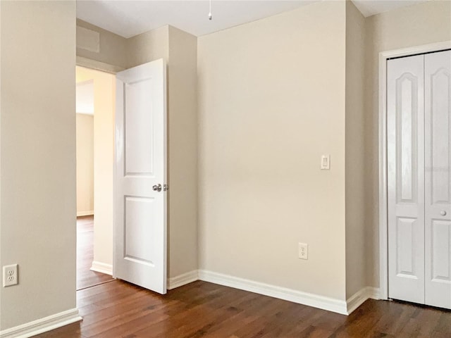 unfurnished bedroom with a closet and dark hardwood / wood-style flooring