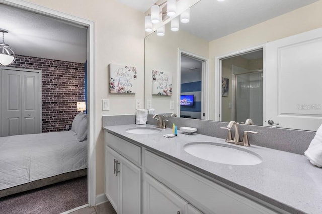 bathroom featuring vanity and brick wall