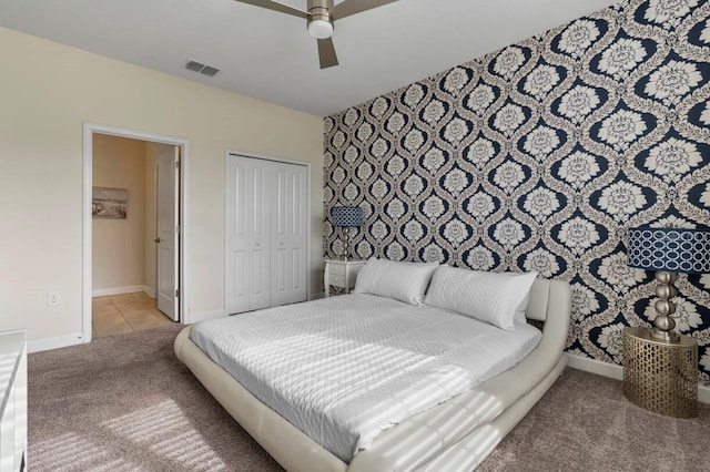 carpeted bedroom with ceiling fan and a closet