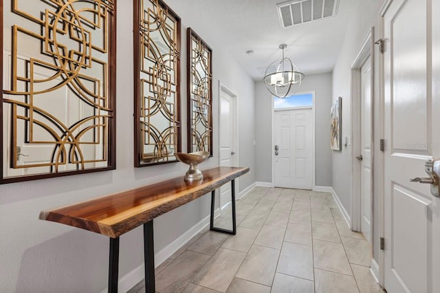 entrance foyer featuring light tile patterned flooring and a chandelier