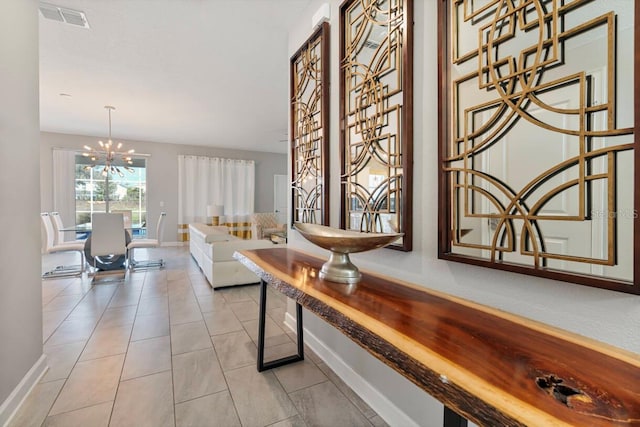 hallway featuring light tile patterned flooring and a chandelier