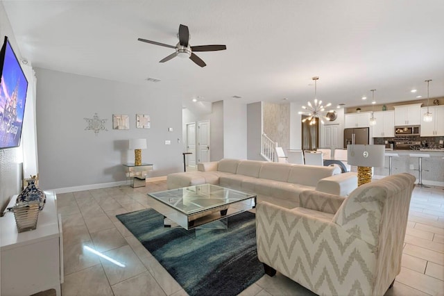 living room featuring ceiling fan with notable chandelier