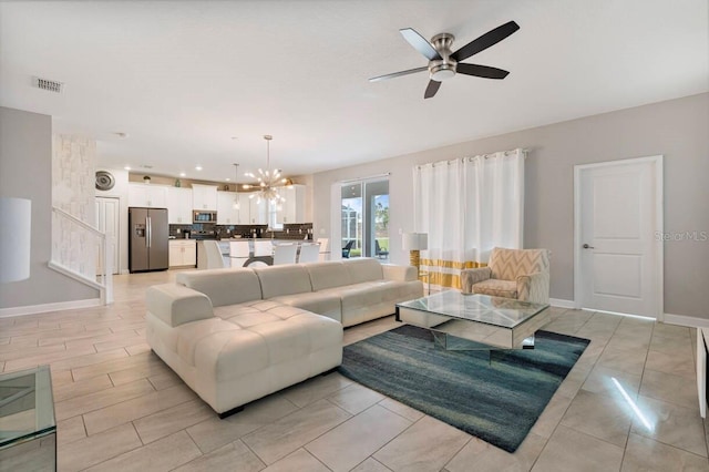 living room with ceiling fan with notable chandelier