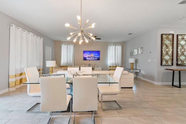 dining space featuring brick wall, light tile patterned floors, and a chandelier