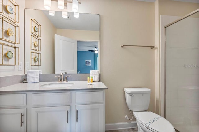 bathroom with vanity, ceiling fan, a shower with door, and toilet