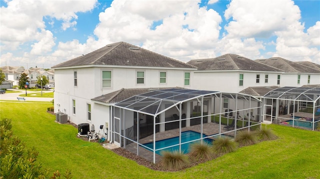 rear view of property featuring a yard, a lanai, a patio, and central AC unit