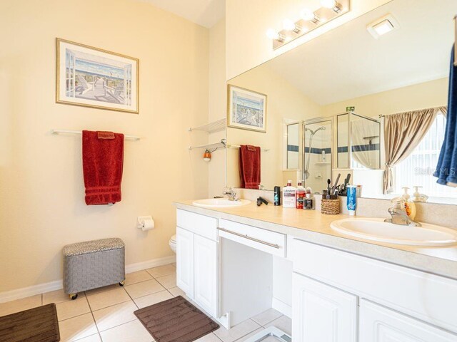 bathroom featuring tile patterned flooring, vanity, an enclosed shower, and toilet