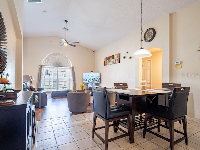 dining area with ceiling fan, light tile patterned floors, and high vaulted ceiling