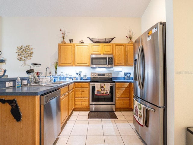 kitchen featuring appliances with stainless steel finishes, sink, and light tile patterned flooring