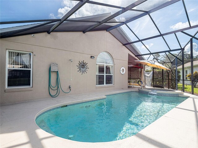 view of swimming pool featuring glass enclosure, a patio area, and an in ground hot tub