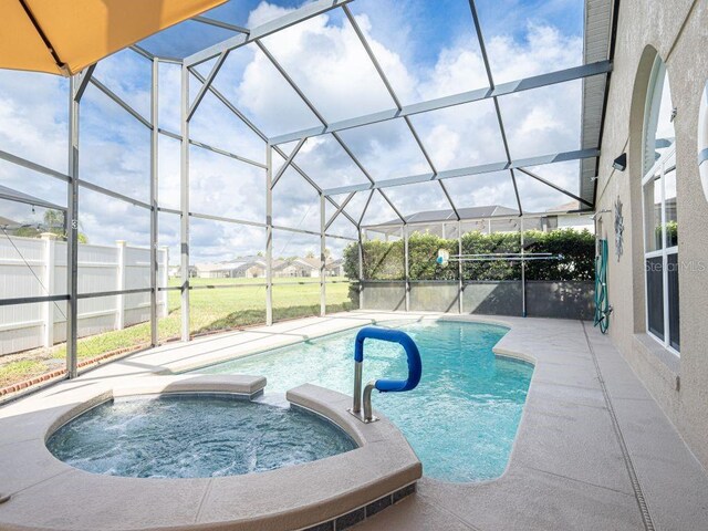 view of swimming pool featuring glass enclosure and an in ground hot tub