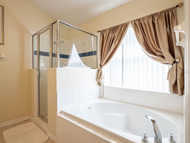 bathroom with tile patterned floors, a wealth of natural light, and plus walk in shower