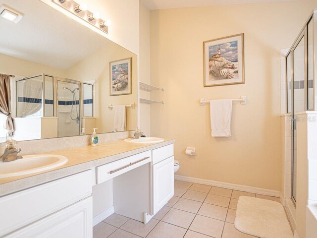 bathroom with toilet, vanity, tile patterned floors, and walk in shower