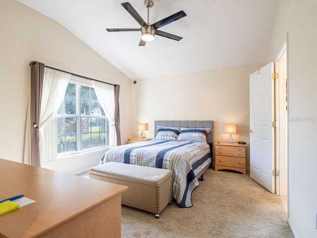 bedroom featuring ceiling fan, light colored carpet, and vaulted ceiling