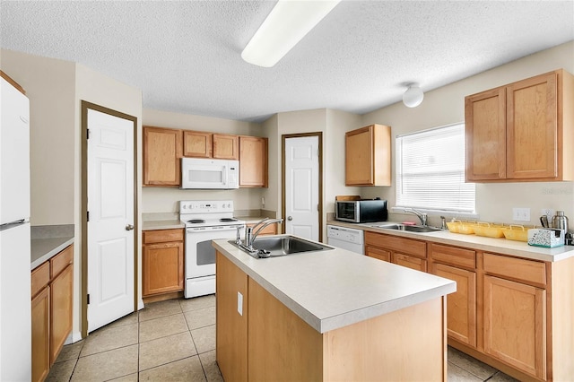 kitchen with sink, white appliances, a textured ceiling, and an island with sink