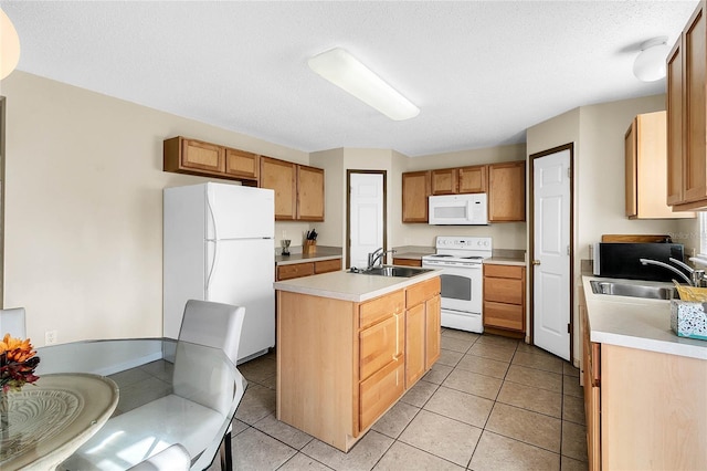 kitchen with sink, white appliances, light tile patterned floors, and an island with sink